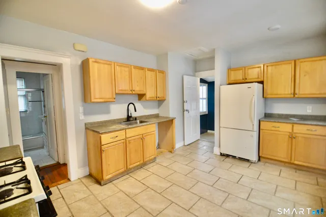 a kitchen with a refrigerator a stove a sink and a window