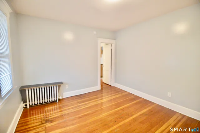 en empty room with wooden floor and fan