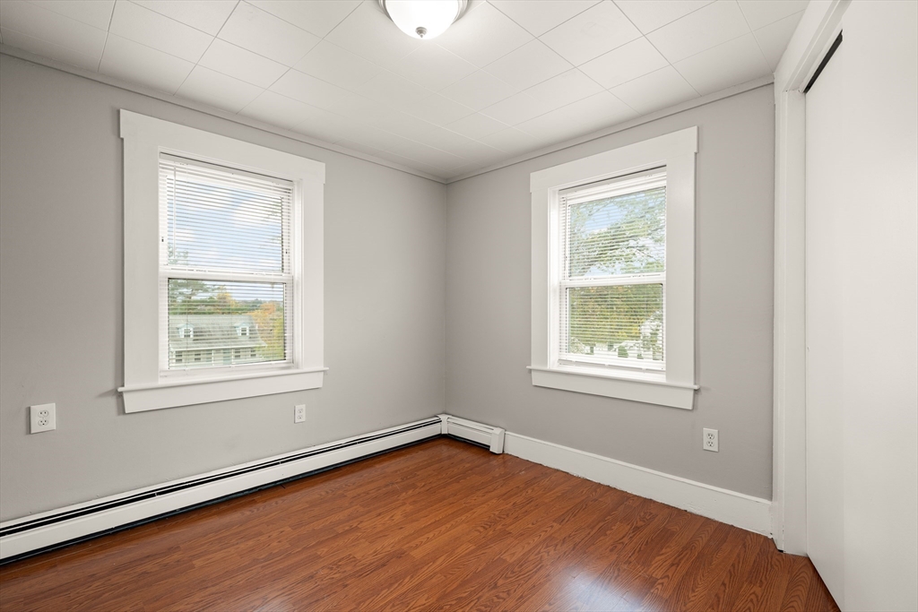 93 Bay State Road Methuen, MA 01844 - Photo 14 of 23 an empty room with wooden floor and windows