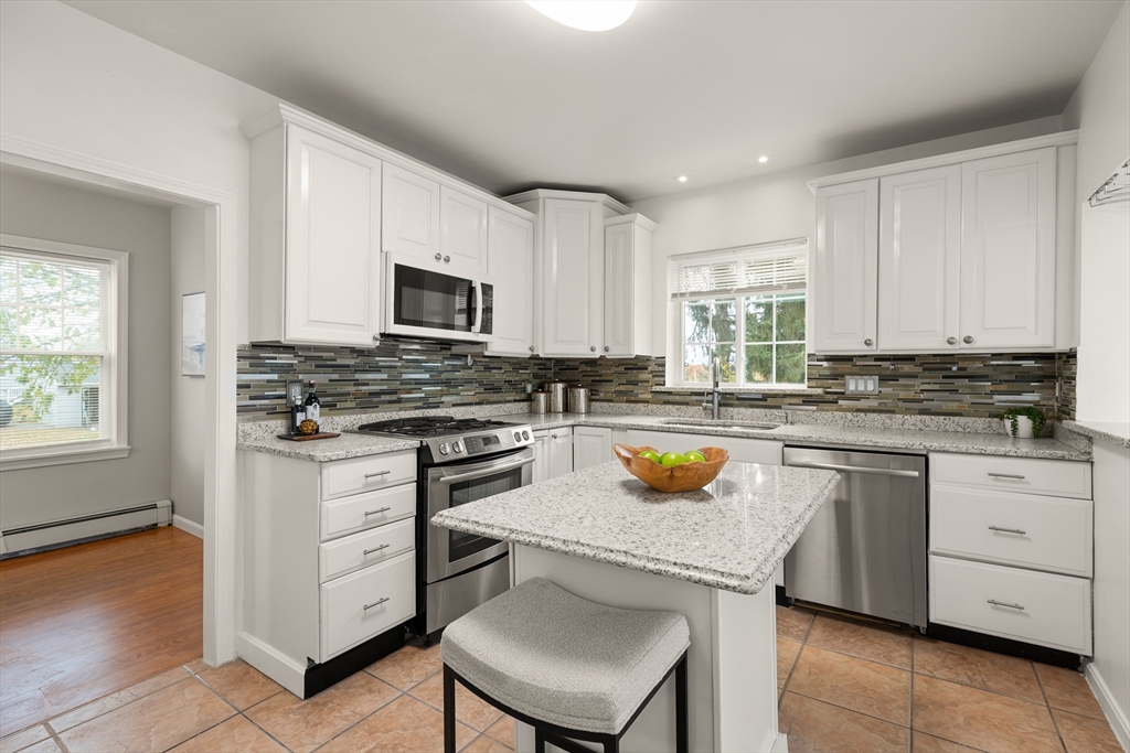 93 Bay State Road Methuen, MA 01844 - Photo 8 of 23 a kitchen with stainless steel appliances a stove sink microwave and cabinets