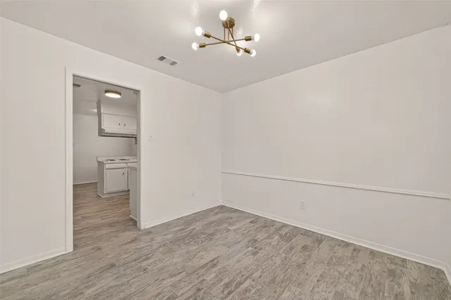 a view of a room with wooden floor and a ceiling fan