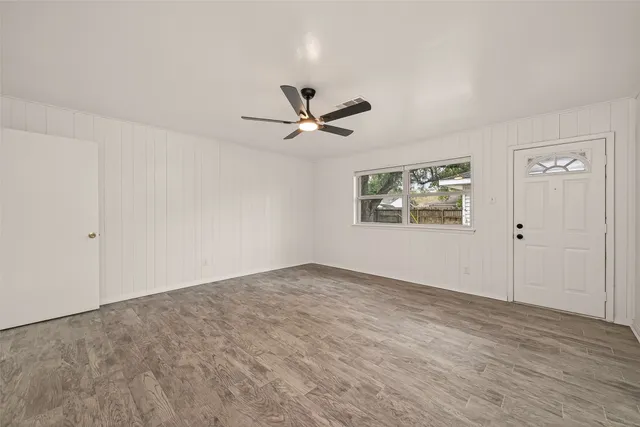an empty room with fan and windows