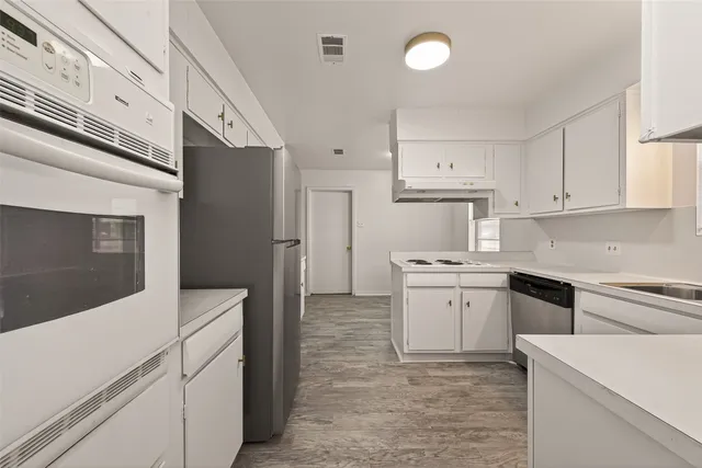 a kitchen with cabinets stainless steel appliances and sink