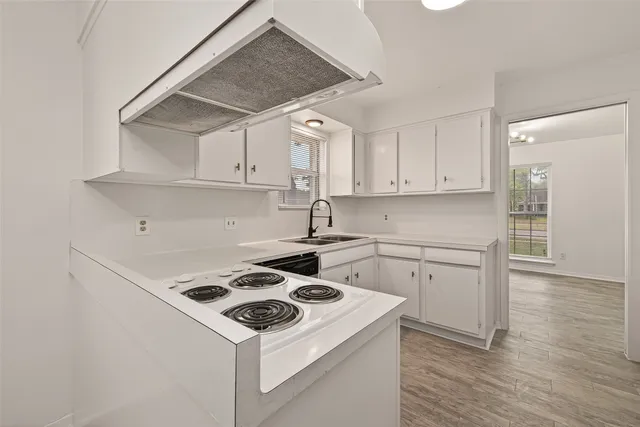 a kitchen with a stove cabinets and wooden floor