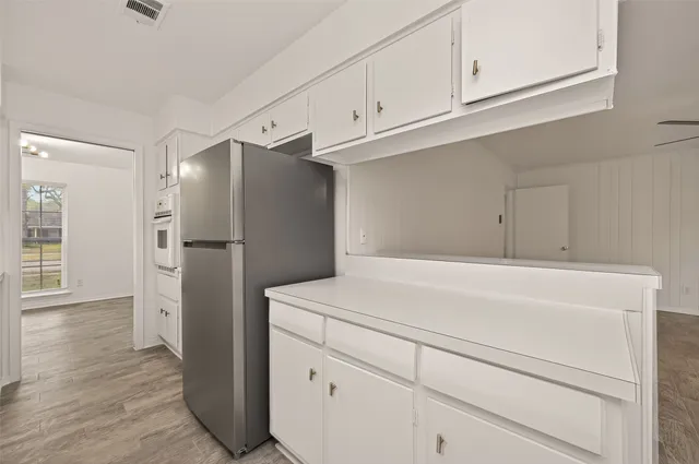 a kitchen with cabinets and a refrigerator