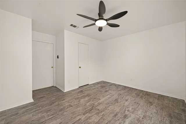an empty room with a window and a fan