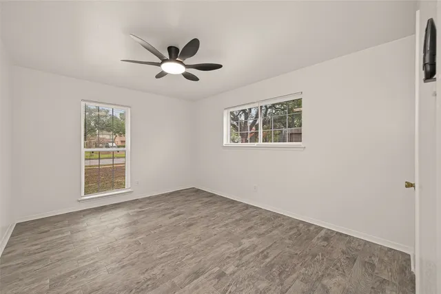 a view of an empty room with a window and a ceiling fan