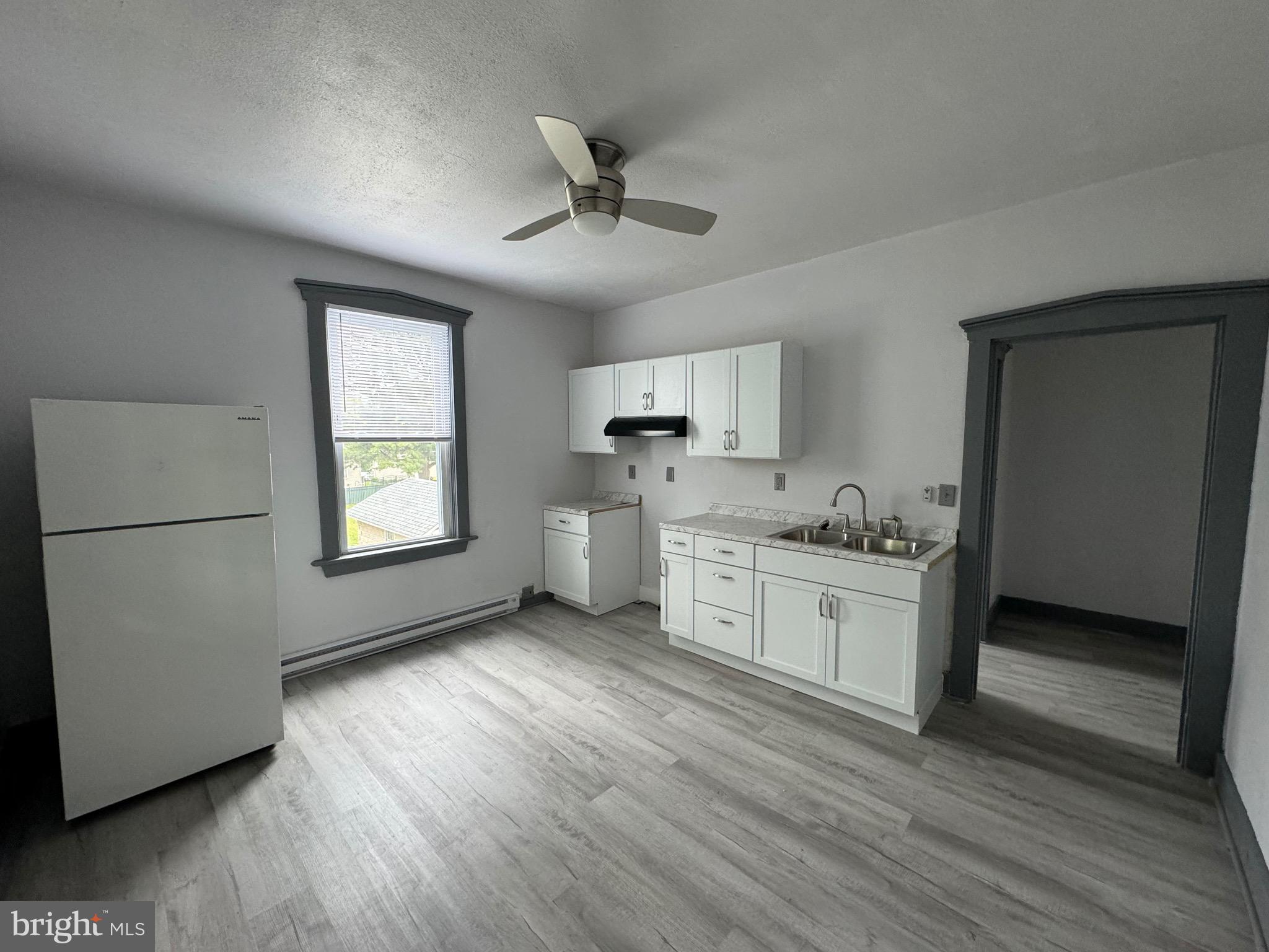 a kitchen with a refrigerator and a stove top oven