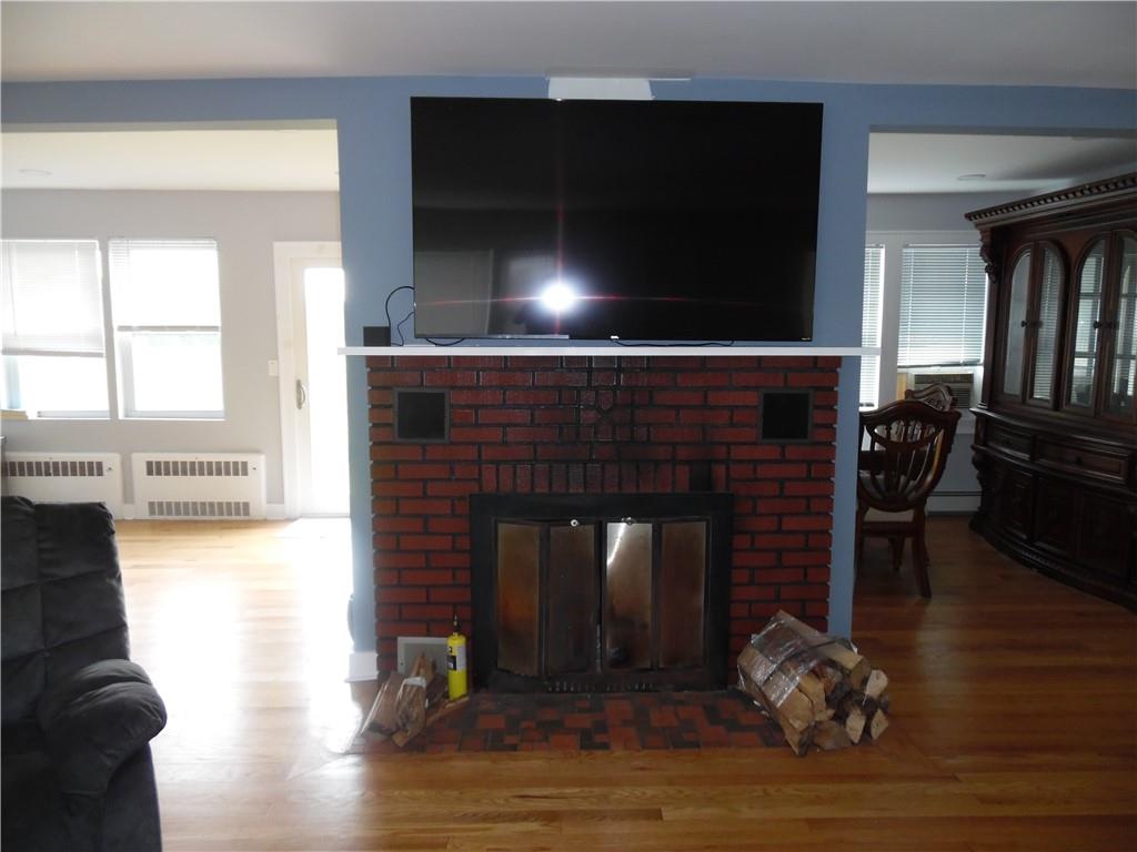 105 Dr Duggan Road Bethel, NY 12720 - Photo 26 of 29 Living room featuring a fireplace, wood-type flooring, and radiator