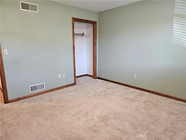 an empty room with closet and a window