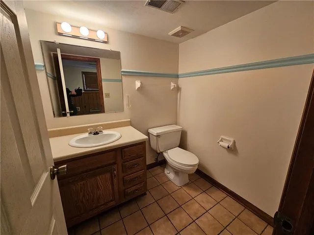 a bathroom with a toilet a sink and mirror