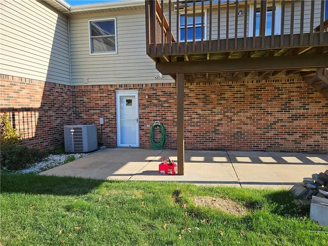 a backyard of a house with wooden fence and a tree