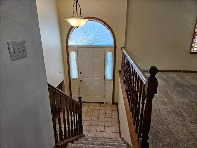 a view of staircase with railing and white walls