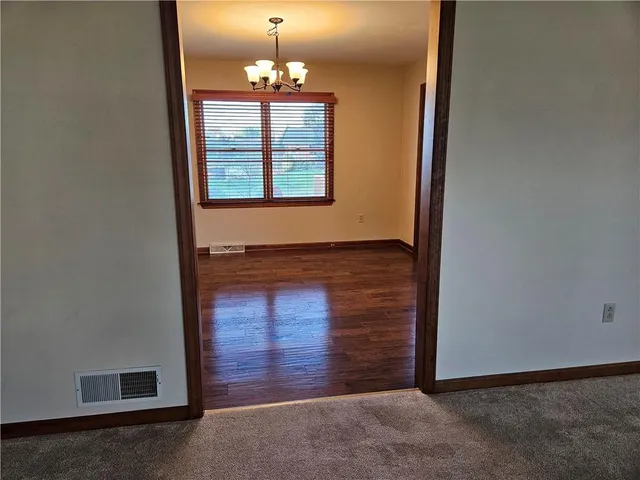 an empty room with chandelier fan