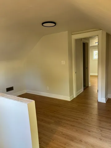 a view of a room with wooden floor