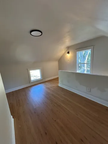 a kitchen with granite countertop a refrigerator and wooden floors