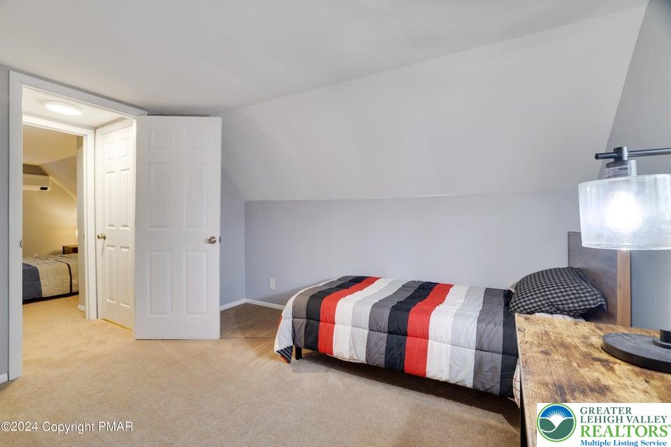3176 Cherry Ridge Road Bushkill, PA 18324 - Photo 28 of 37 a bedroom with a bed and a lamp