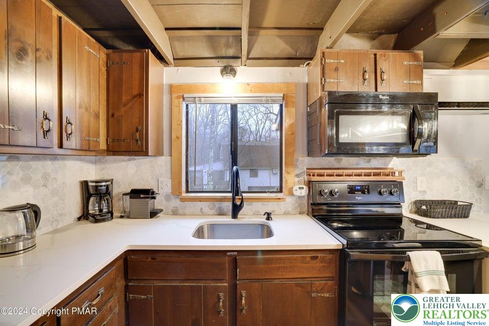 3176 Cherry Ridge Road Bushkill, PA 18324 - Photo 10 of 37 a kitchen with stainless steel appliances a stove a sink and a microwave