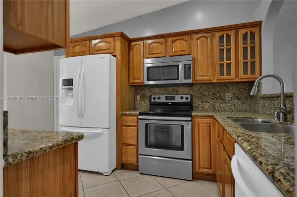 a kitchen with stainless steel appliances granite countertop a sink dishwasher stove and cabinets