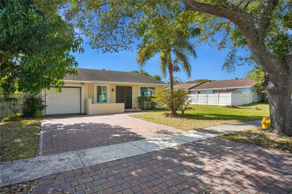 a view of a house with a tree in front of it