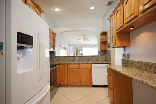 a kitchen with stainless steel appliances granite countertop a sink and a refrigerator