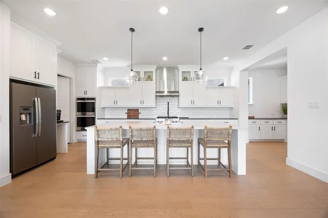 a kitchen with stainless steel appliances kitchen island granite countertop a table and chairs in it