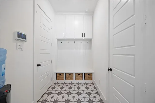 a view of a bedroom with white cabinets and wooden floor