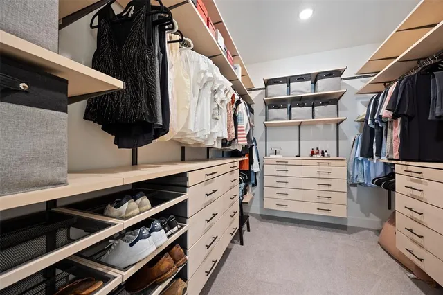 a view of walk in closet with clothes and shoes