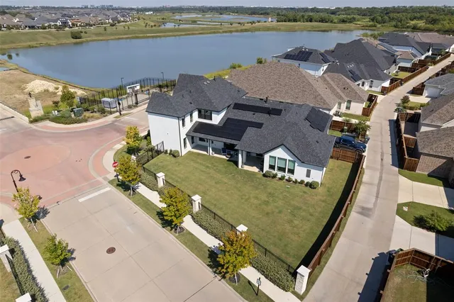 an aerial view of residential houses with outdoor space and lake view