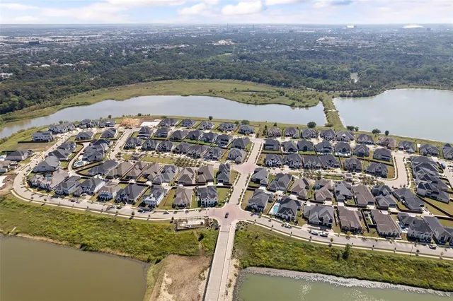 an aerial view of residential houses with outdoor space and lake view