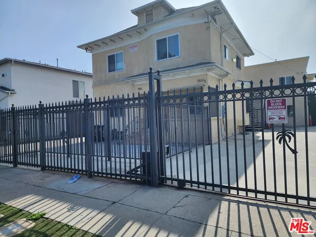 a view of a brick house with wooden fence