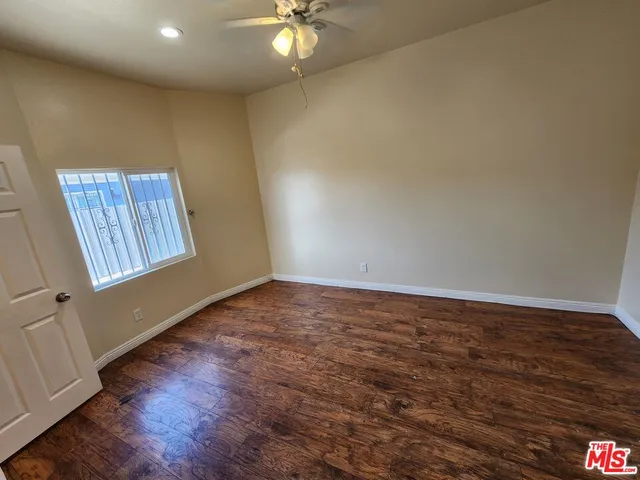 a view of a livingroom with wooden floor and a ceiling fan