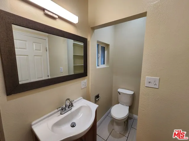 a bathroom with a sink a toilet and mirror