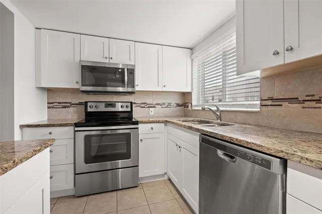 a kitchen with cabinets stainless steel appliances and a sink