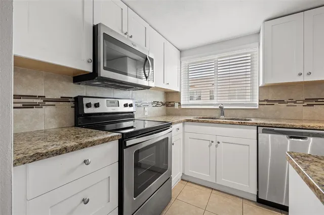 a kitchen with granite countertop a sink and a stove