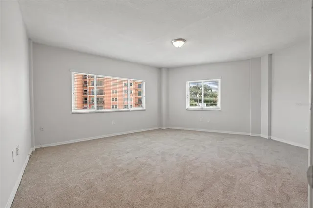 an empty room with windows and closet