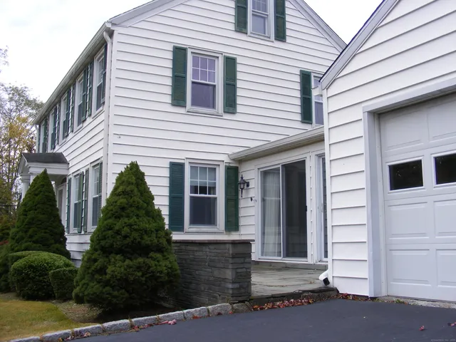 a view of a white house with a large windows and plants