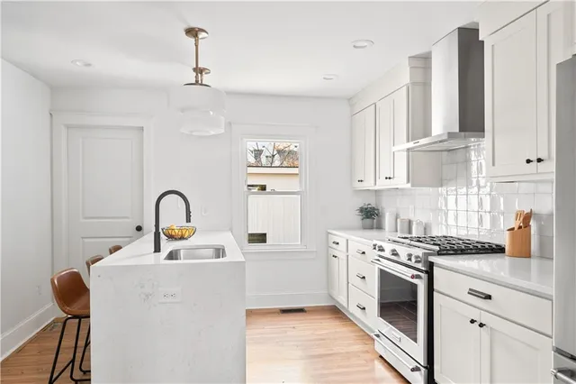 a bedroom with a bed a dresser and wooden floor