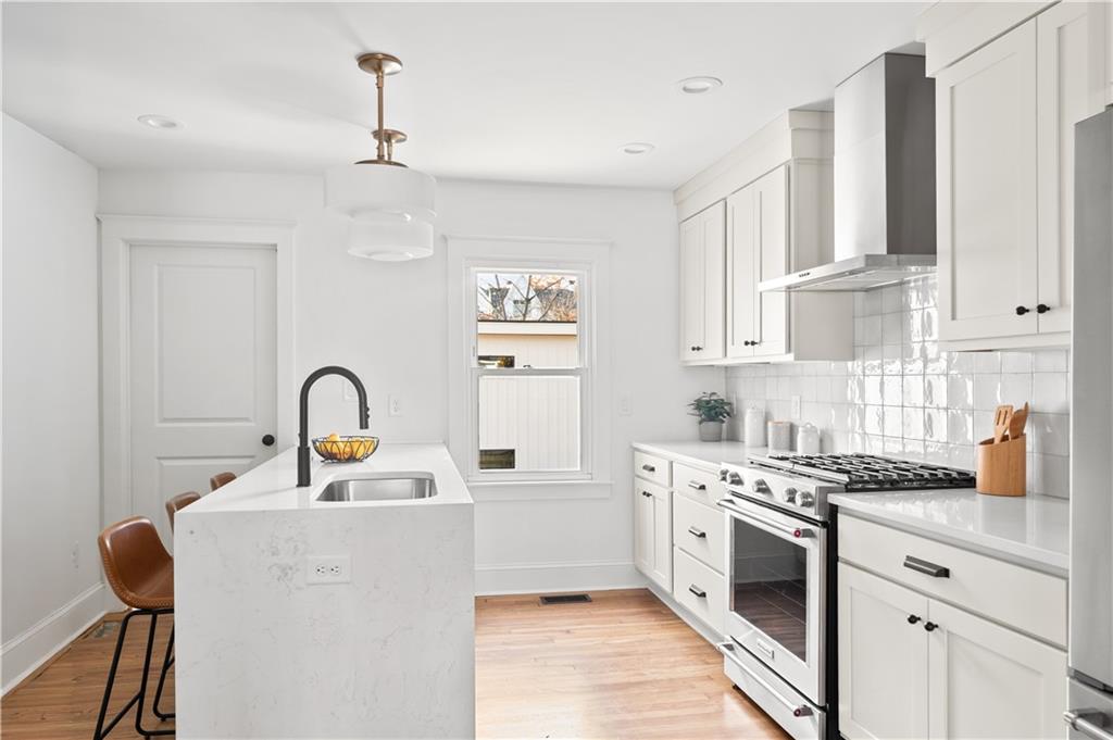 845 Ormewood Terrace Southeast, Unit A Atlanta, GA 30316 - Photo 8 of 34 a kitchen with stainless steel appliances granite countertop a white stove top oven with white cabinets