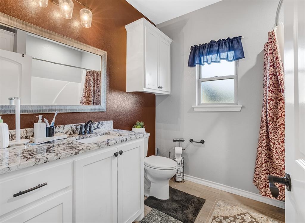 523 Mitchell Ryan Wake Village, TX 75501 - Photo 14 of 37 a bathroom with a granite countertop sink toilet and mirror