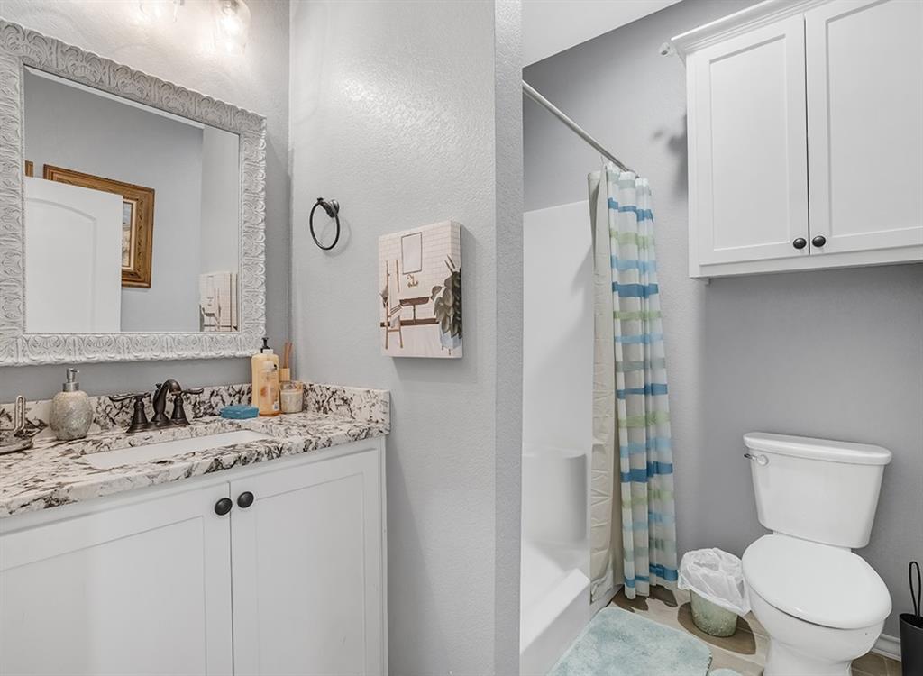 523 Mitchell Ryan Wake Village, TX 75501 - Photo 20 of 37 a bathroom with a granite countertop toilet sink and mirror