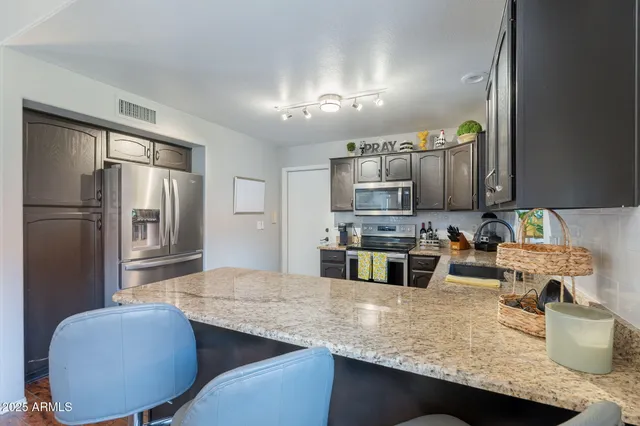 a kitchen with stainless steel appliances granite countertop a sink refrigerator and microwave