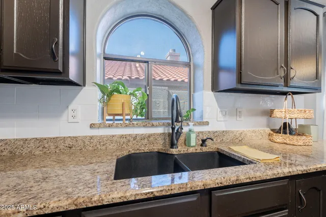 a kitchen with granite countertop a sink stainless steel appliances and cabinets