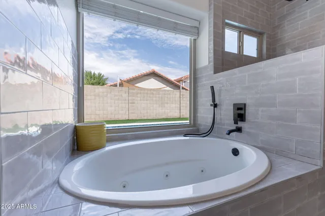 a bathroom with a bathtub and next to a window