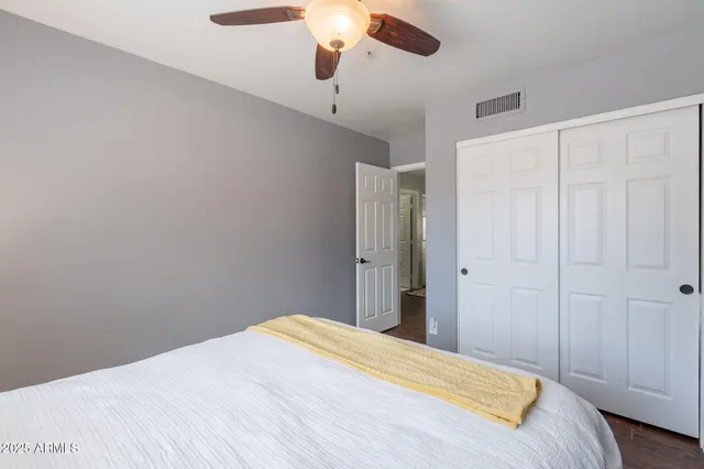 a bedroom with a bed and a chandelier fan