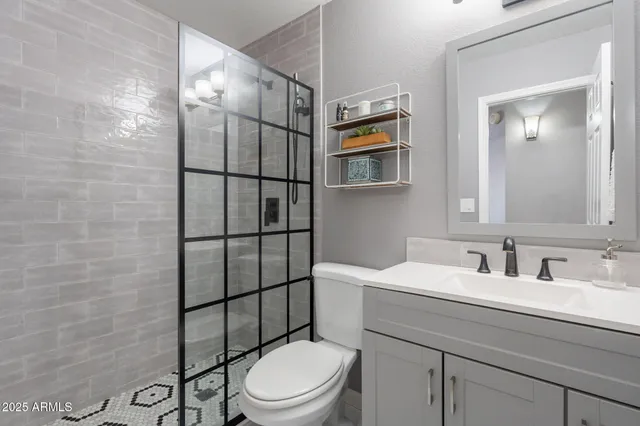 a bathroom with a toilet sink vanity and mirror