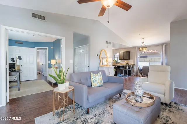 a living room with furniture potted plant and a ceiling fan