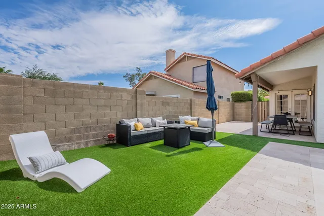 a view of backyard of house with seating area