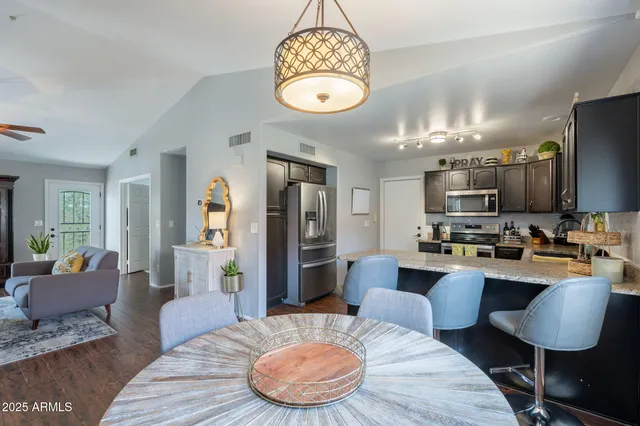 a living room with furniture a chandelier a rug and a large mirror