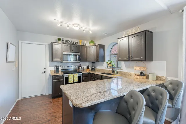 a kitchen with stainless steel appliances granite countertop a sink refrigerator and microwave